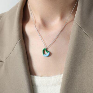 a woman wearing a necklace with a green and blue pendant