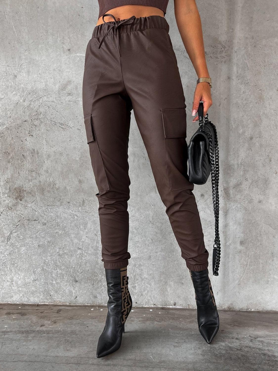 a woman wearing brown pants and black boots