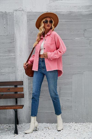 a woman in a pink jacket and hat standing next to a bench
