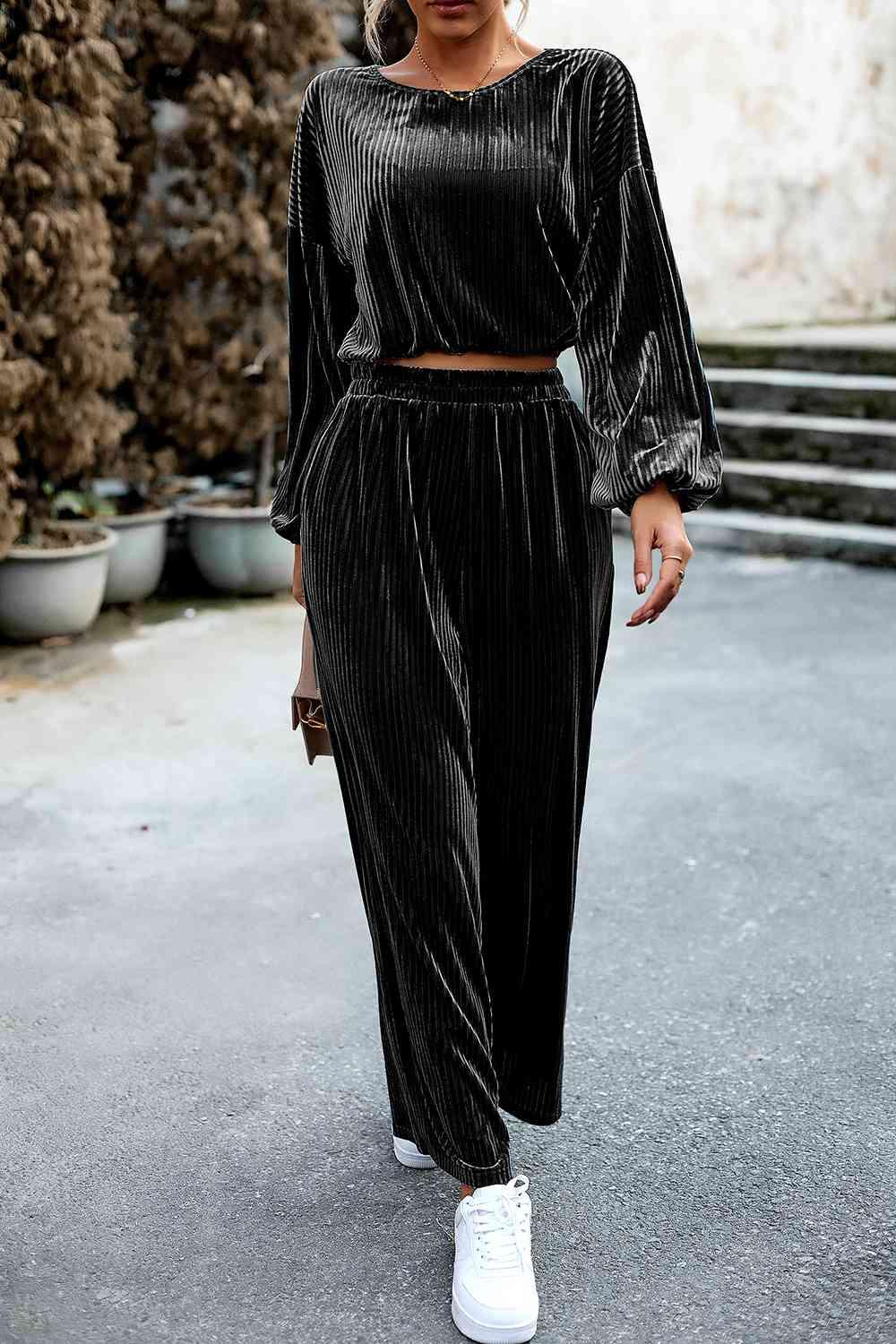 a woman wearing a black velvet two piece set