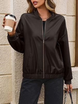 a woman in a black jacket holding a cup of coffee