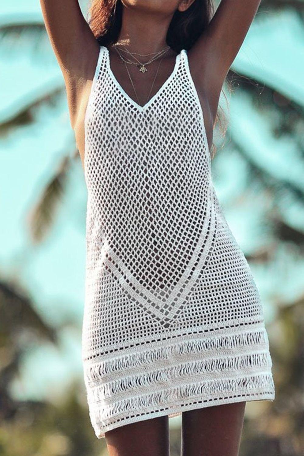 a woman in a white crochet dress holding a surfboard