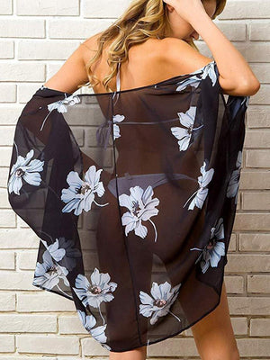 a woman wearing a black and white floral print cover up