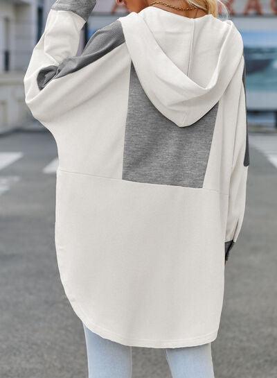 a woman wearing a white and grey hoodie