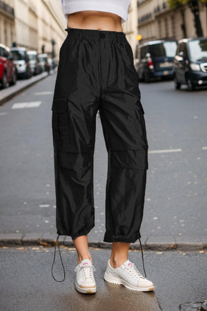 a woman in white shirt and black pants standing on street