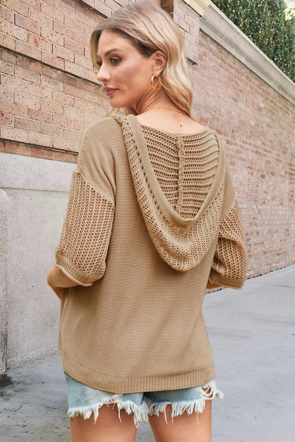 a woman wearing a tan sweater and ripped shorts