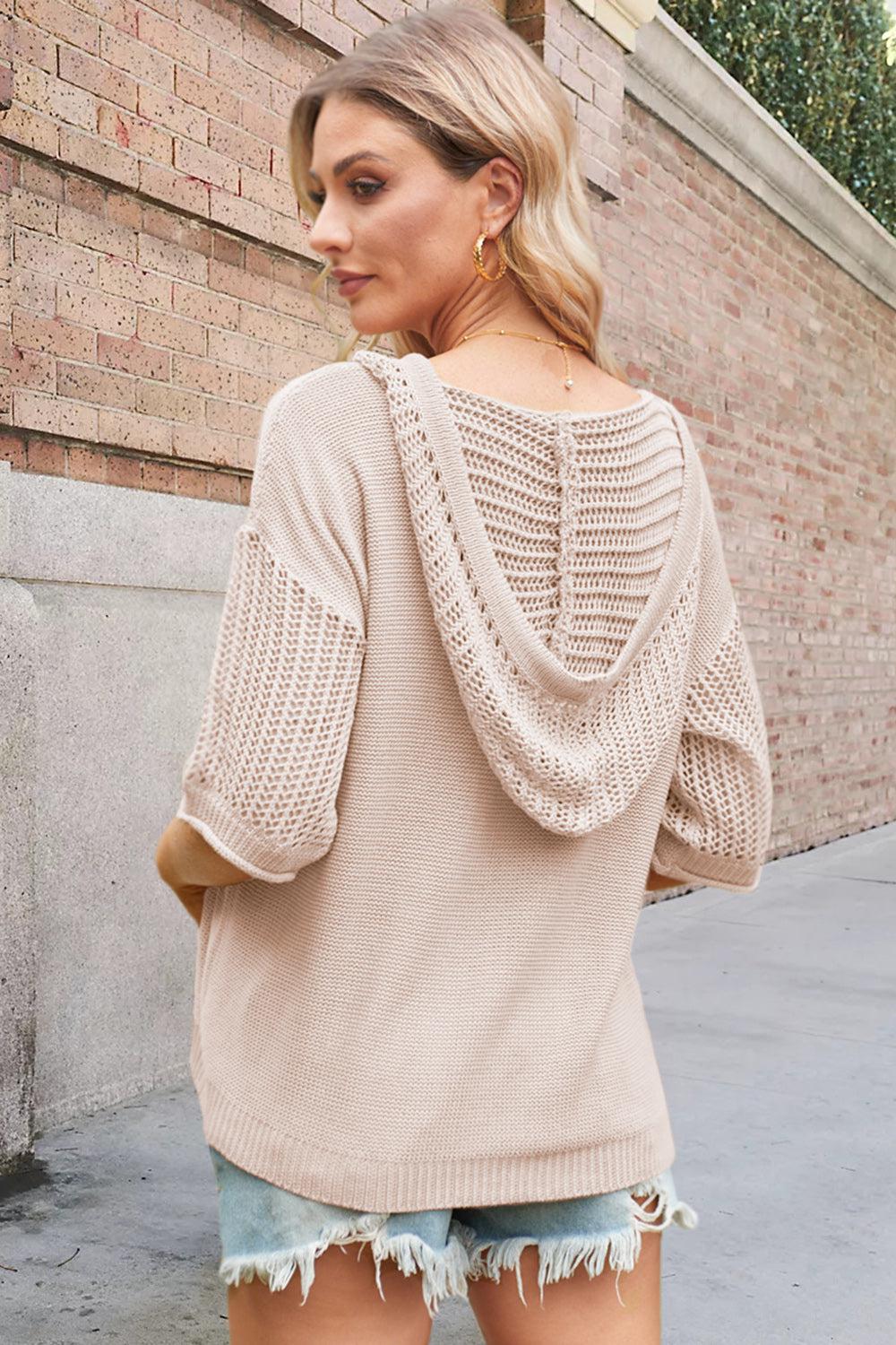 a woman wearing a beige sweater and ripped shorts