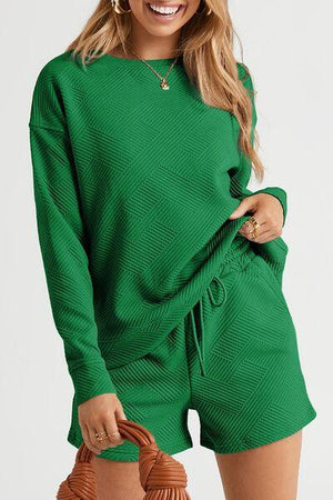 a woman wearing a green sweater and shorts