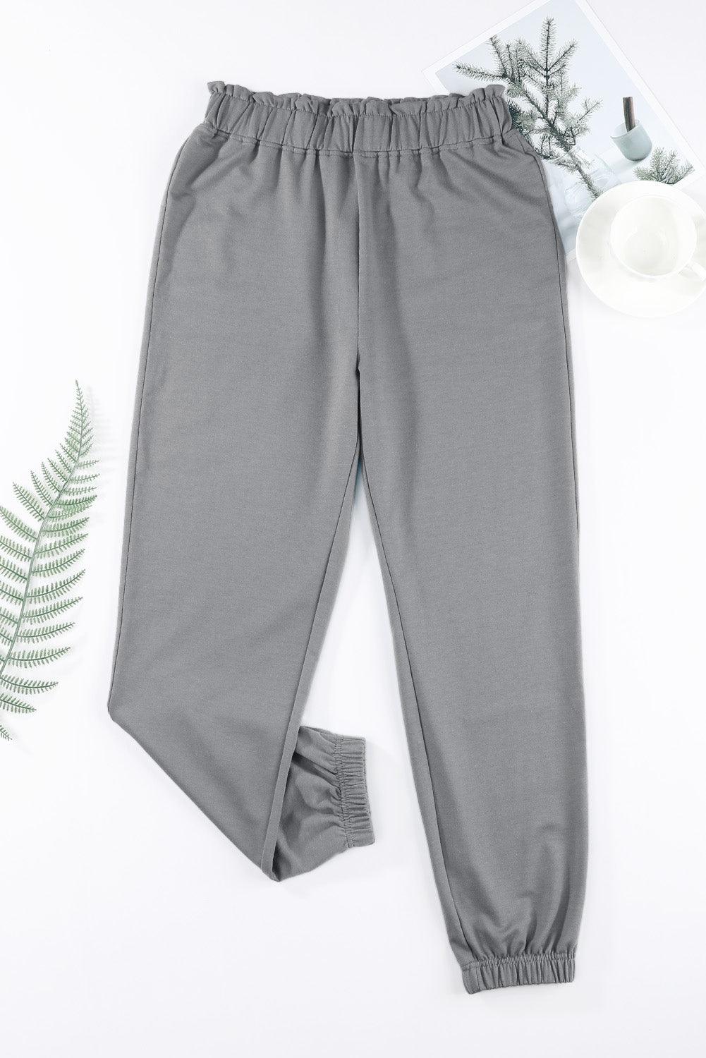 a pair of grey pants next to a plant