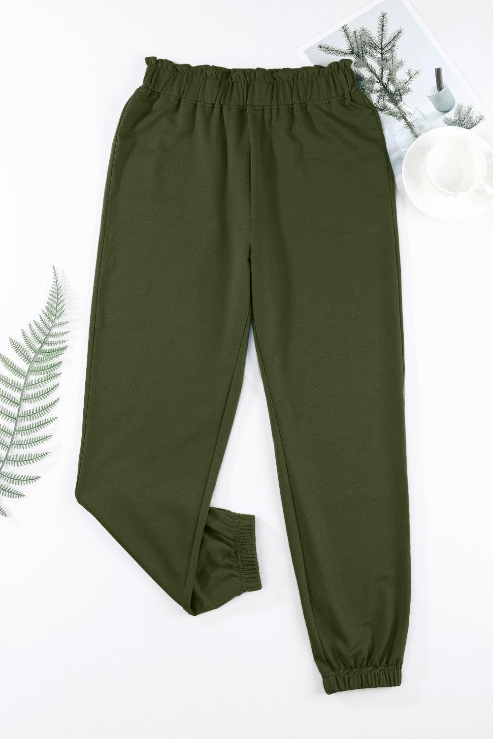 a pair of green pants next to a plant