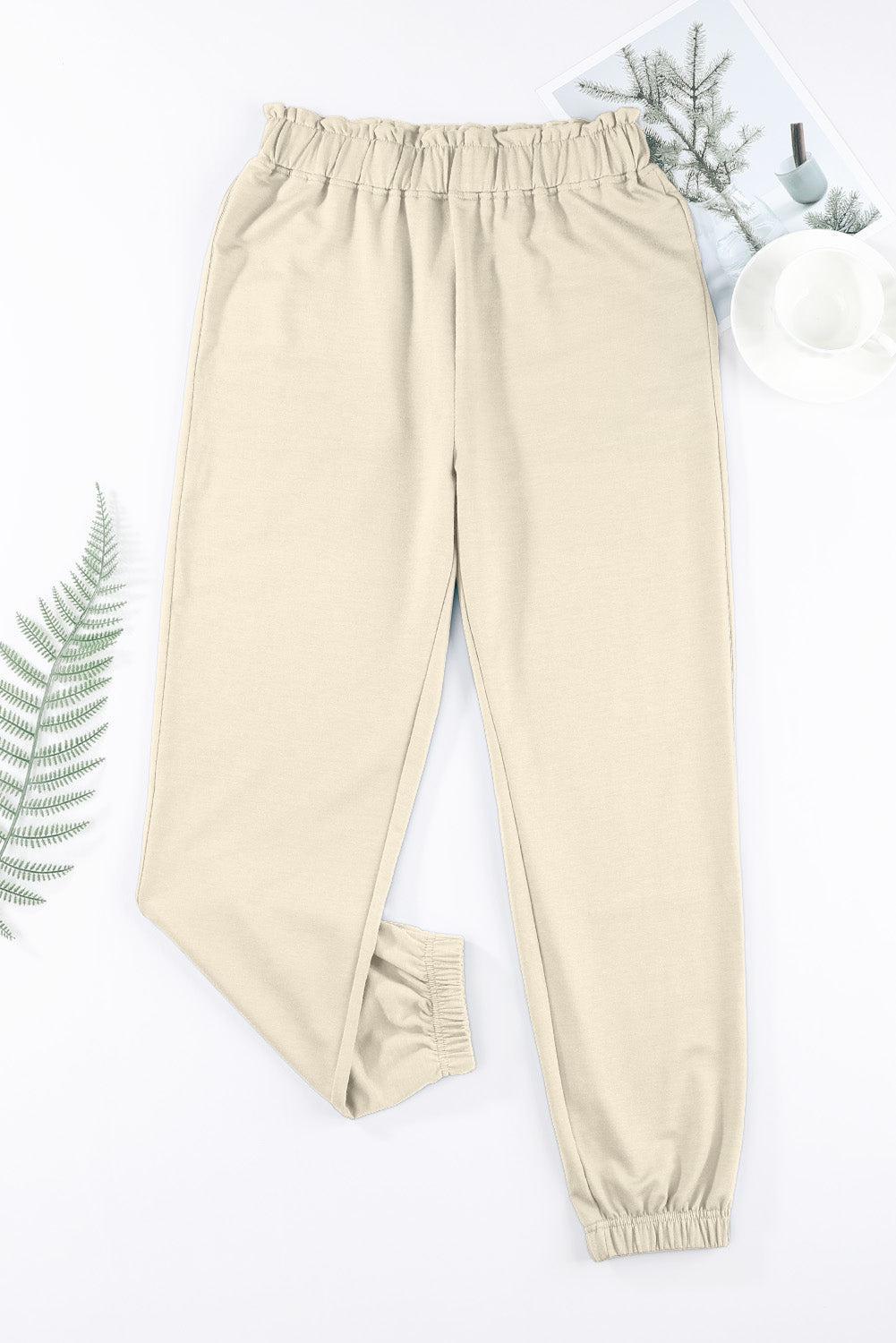 a pair of pants and a plant on a white surface