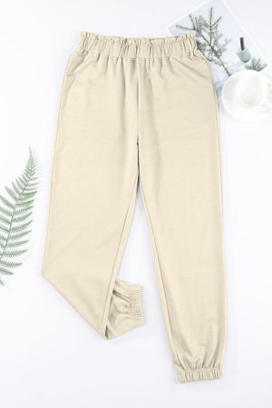 a pair of pants and a plant on a white surface