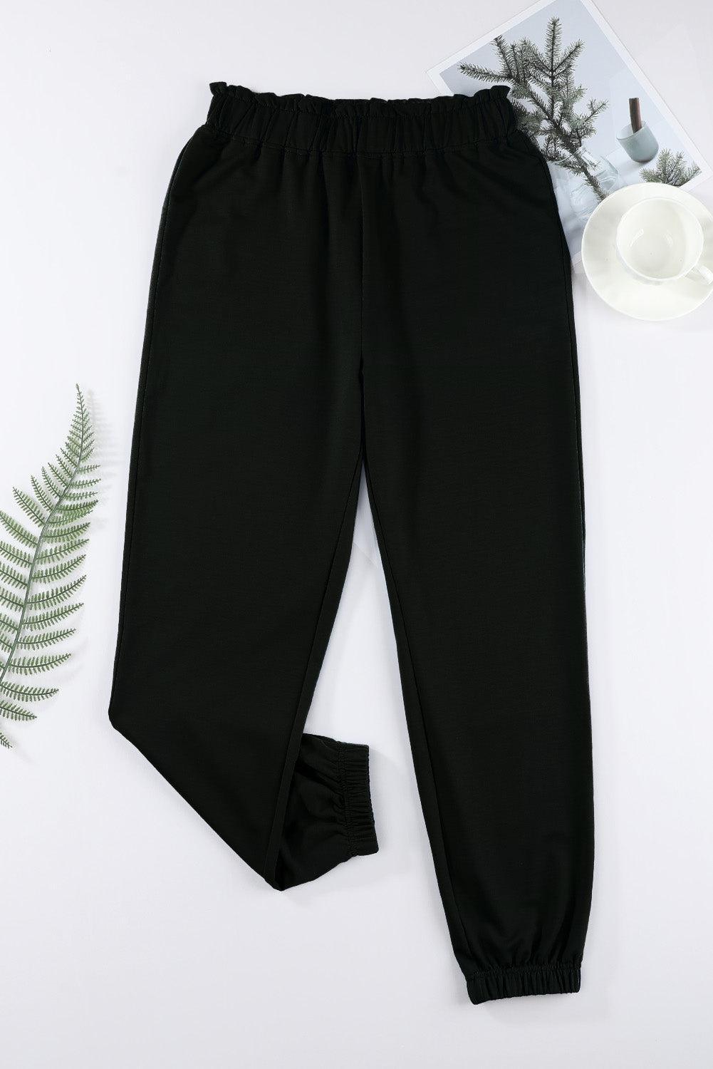 a pair of black pants next to a plant