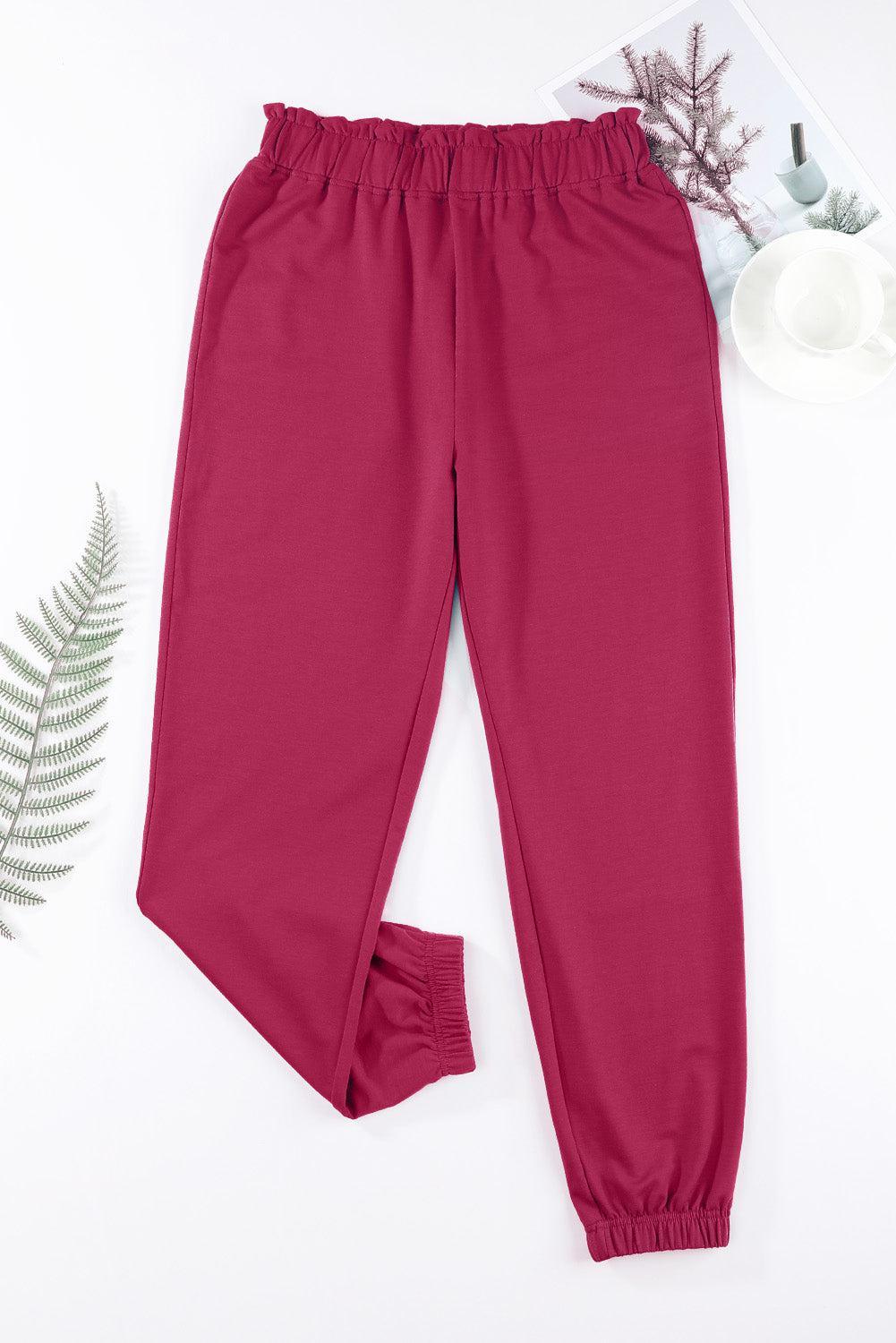 a pair of pink pants with a plant next to it