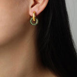 a close up of a person wearing a pair of earrings