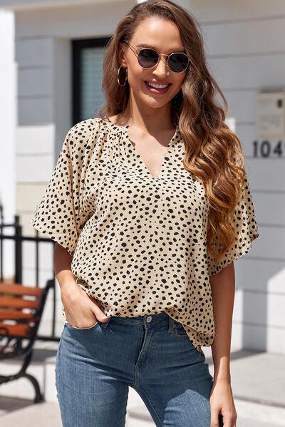 a woman wearing a polka dot blouse and jeans