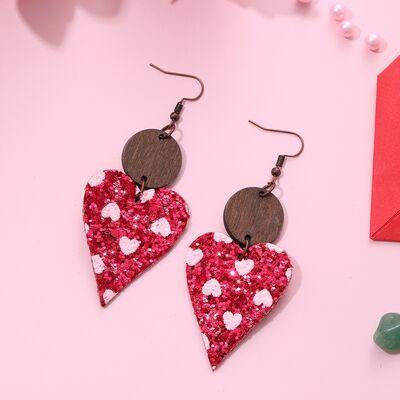 a pair of heart shaped earrings sitting on top of a table