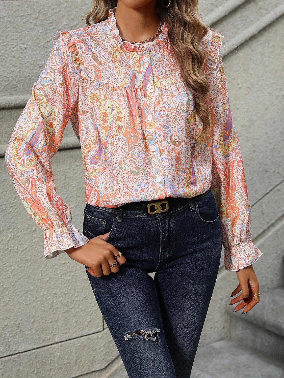 a woman in jeans and a blouse posing for a picture