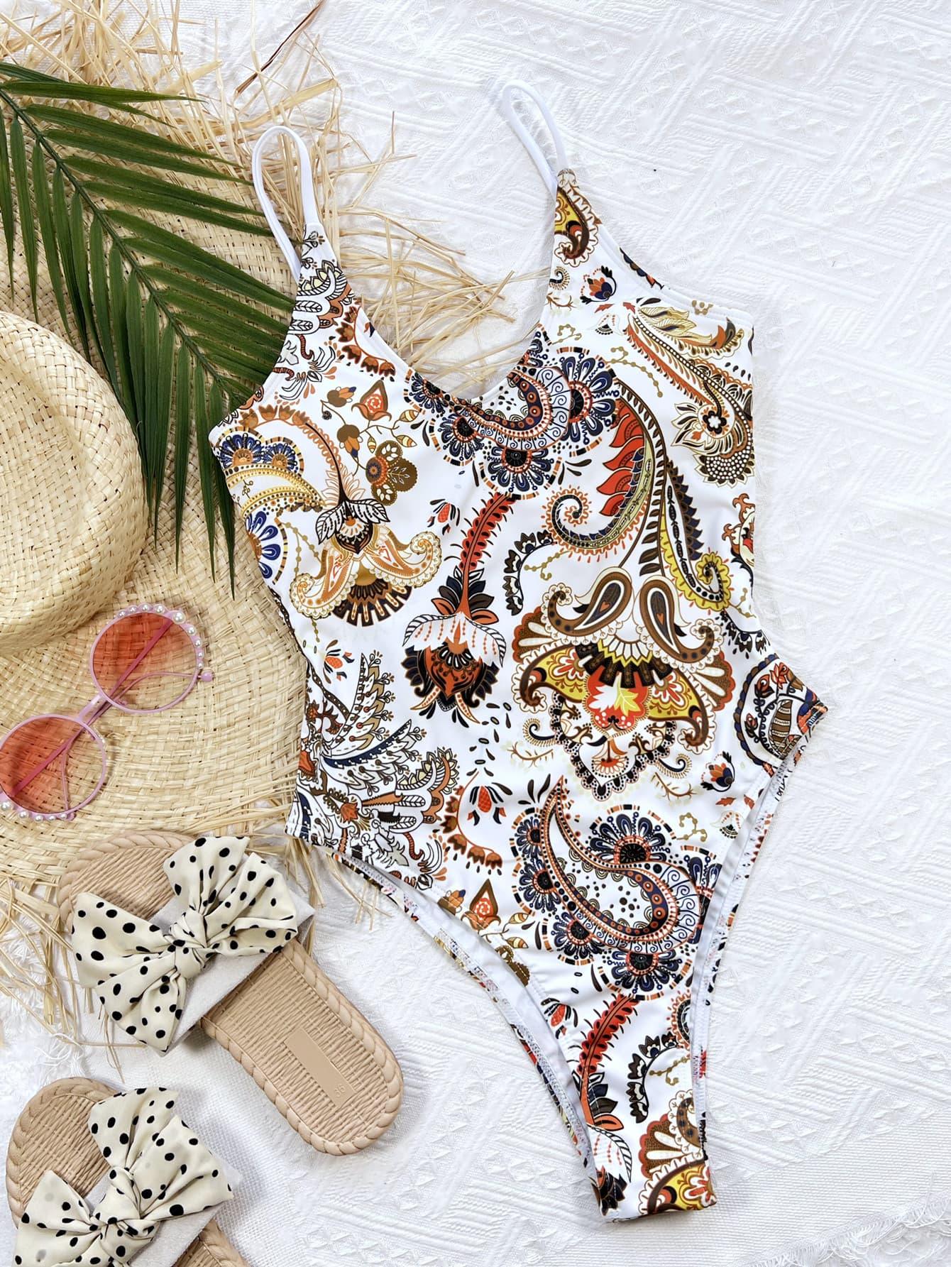 a bathing suit, hat, sunglasses, and flip flops are laid out on