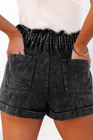 a woman wearing a pair of shorts with her hands in her pockets
