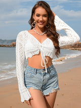 a beautiful woman standing on top of a sandy beach