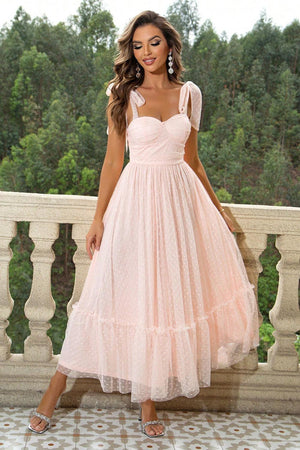 a woman in a pink dress standing on a balcony