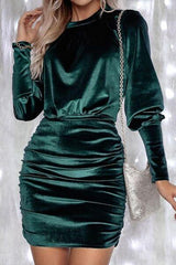 a woman wearing a green velvet dress