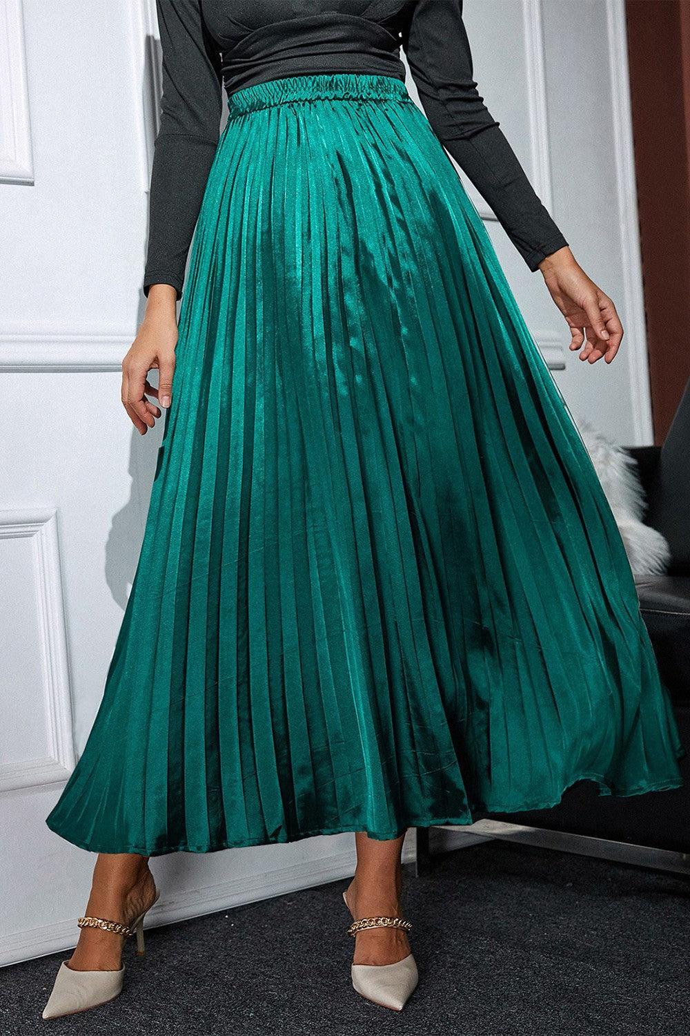 a woman wearing a green pleated skirt