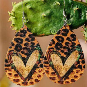 a pair of leopard print earrings hanging from a cactus