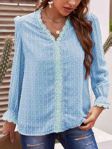 a woman wearing a blue blouse and jeans