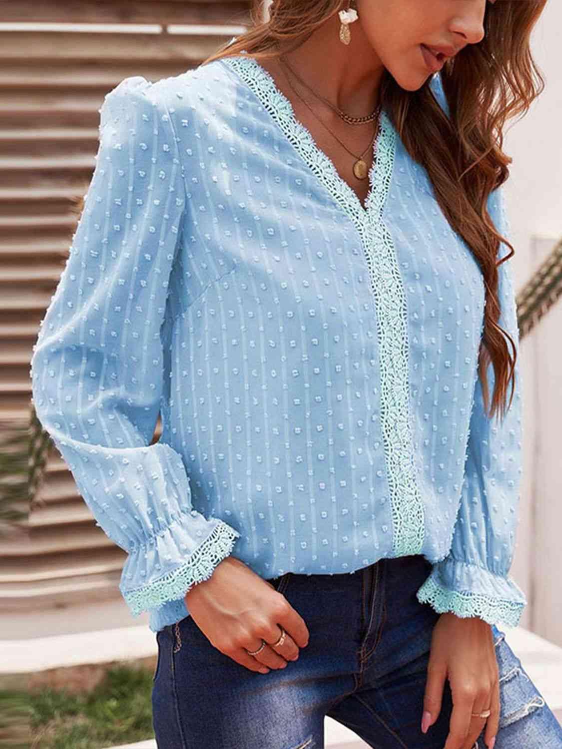 a woman wearing a blue blouse and jeans