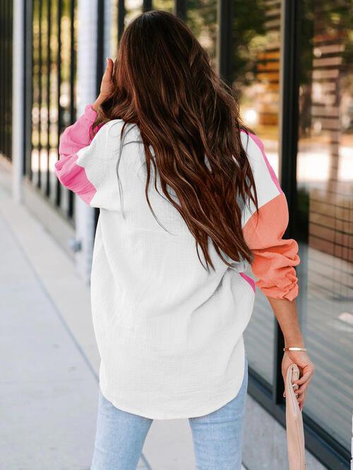 a woman walking down a sidewalk holding a pink umbrella