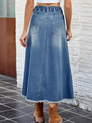 a woman in a white top and a denim skirt