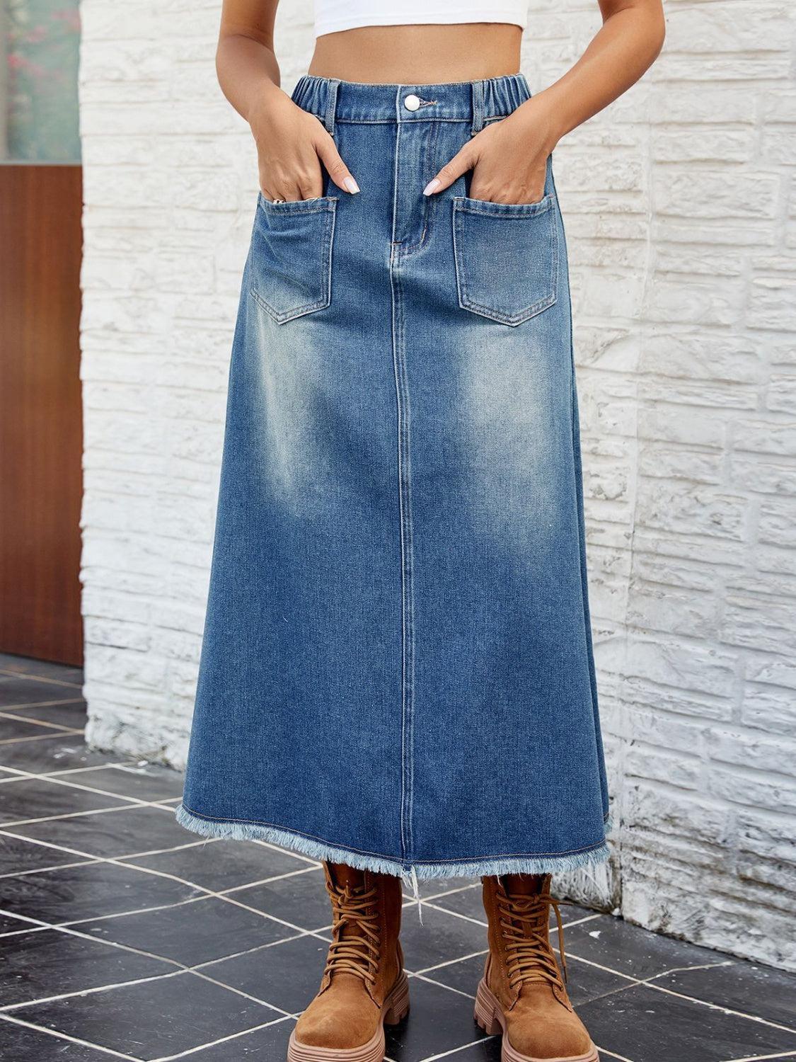 a woman in a white crop top and a denim skirt