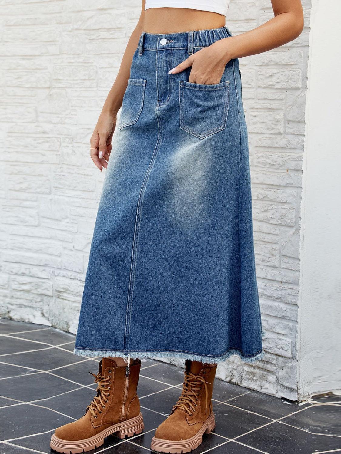 a woman in a white crop top and a denim skirt
