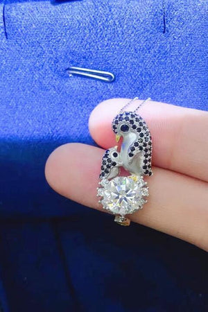 a person's hand holding a ring with a bird on it