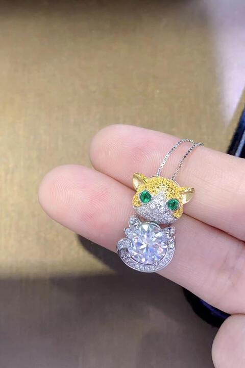 a person's hand holding a diamond and emerald cat ring