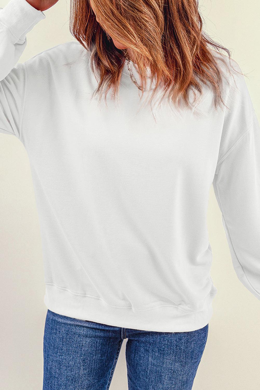a woman wearing a white sweatshirt and jeans