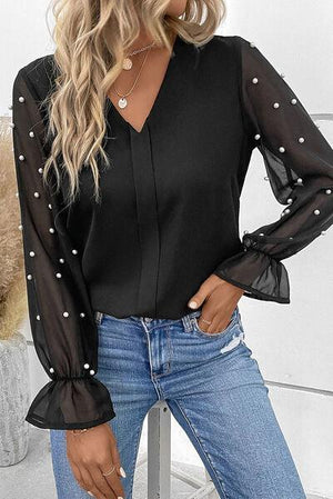 a woman wearing a black blouse and jeans