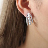 a close up of a person wearing a pair of earrings