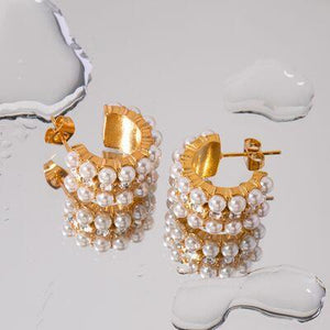 a pair of gold and pearl earrings