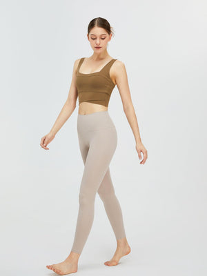 a woman in a tan top and leggings