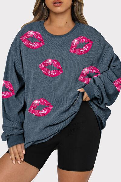 a woman wearing a blue sweater with pink lips on it