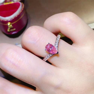 a woman's hand with a pink ring on it