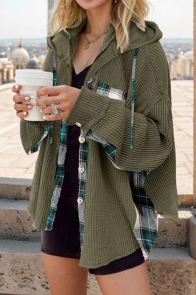 a woman in a green jacket holding a cup of coffee