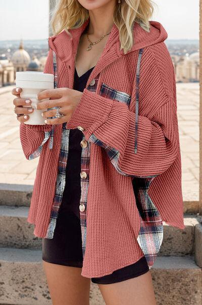 a woman in a red jacket holding a cup of coffee