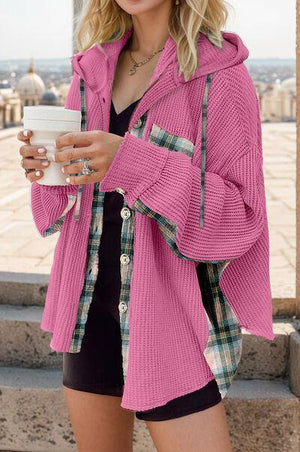 a woman in a pink jacket holding a cup of coffee