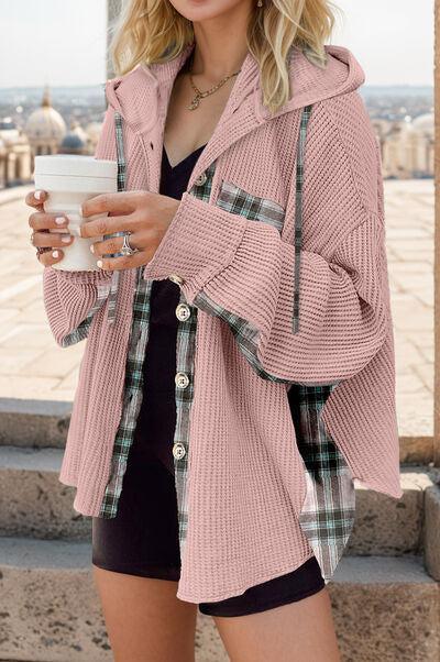 a woman in a pink jacket holding a cup of coffee