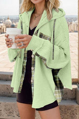 a woman in a green jacket holding a cup of coffee