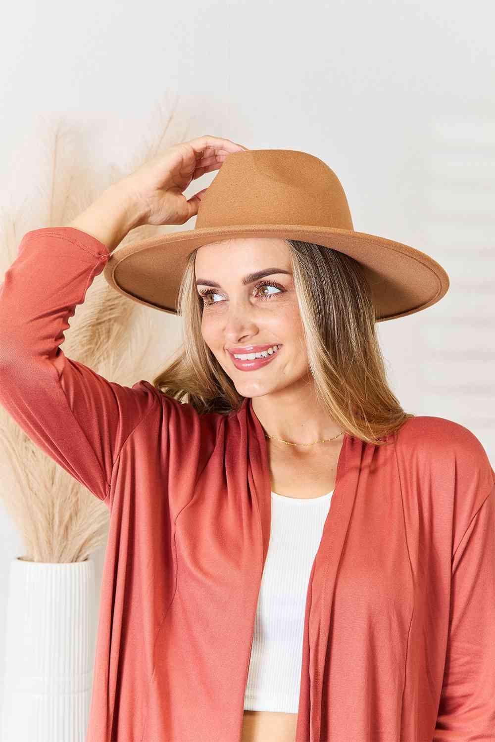 a woman wearing a brown hat and cardigan